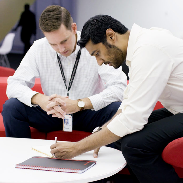 A Kelley School of Business graduate student works with a colleague during a summer business internship at 3M. 
