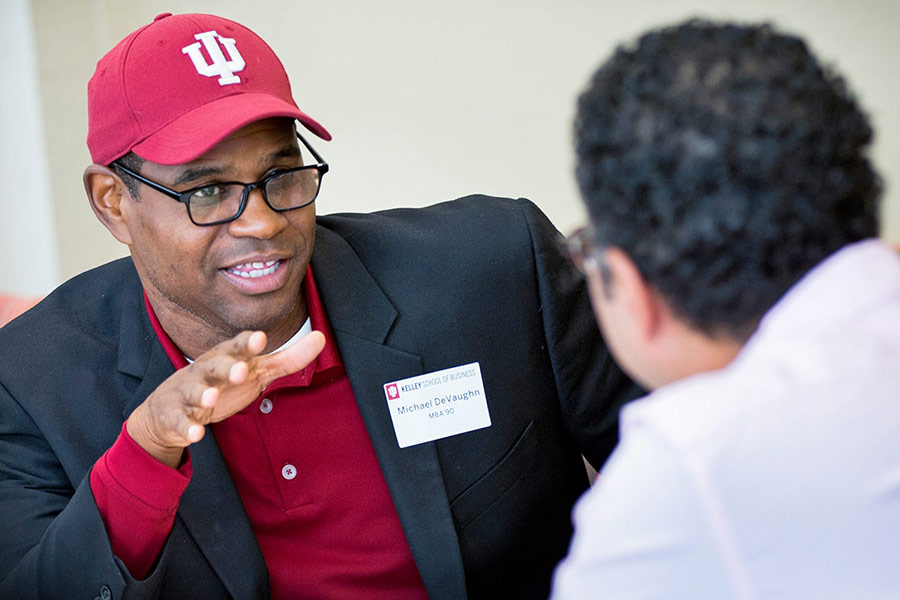 Two Kelley School of Business alumni members talk to each other at an event. 
