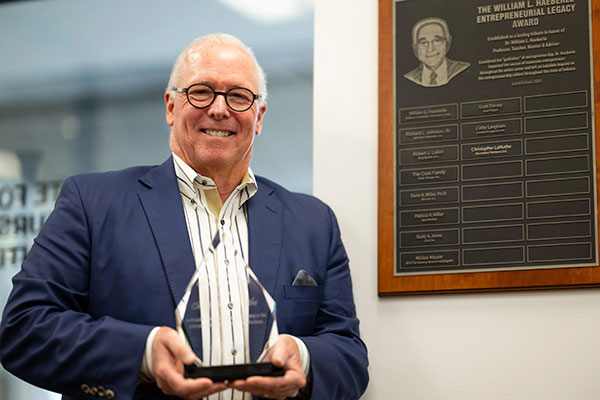 Christopher LaMothe holding the glass William L. Haeberle Entrepreneurial Legacy Award