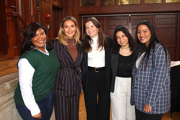 Group of women standing and smiling together at the annual Women in Business Leaders Conference