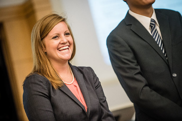 An Indiana full-time MBA student laughing with a classsmate during a presentation