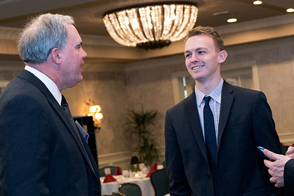 A Kelley School of Business student talks with a faculty member at a networking event. 