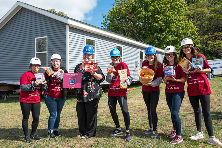Volunteers from the Kelley School of Business at the 2022 Whirlpool Habitat Build hold the snacks provided to the volunteer teams.